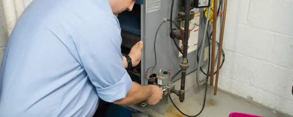 Furnace repair technician inspecting and servicing a home heating system in Andover, MA