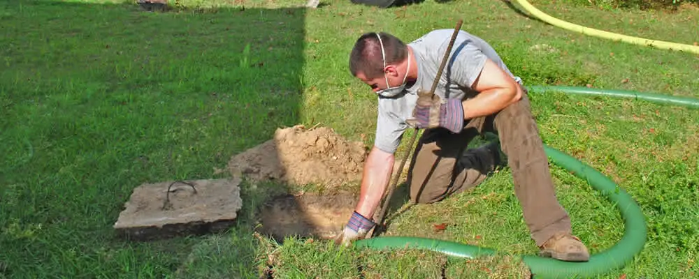 Septic pumping technician servicing a residential septic tank in Andover, MA